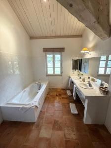 a large bathroom with two sinks and a tub at Château Gautoul in Puy-lʼÉvêque