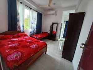 a bedroom with a bed with a red comforter at MSM DIAMOND GUEST HOUSE lk in Ragama