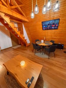 a room with a table and chairs and stairs at Art A Cabin in Teşila