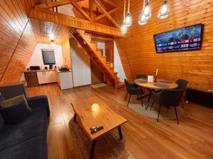a living room with a couch and a table at Art A Cabin in Teşila