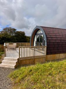 a small cabin with a wooden deck and a bench at Byrnside Lodge in Latheron