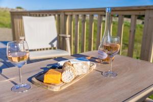 a table with two glasses of wine and cheese at Byrnside Lodge in Latheron