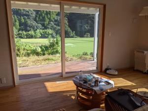 ein Wohnzimmer mit einer großen Glasschiebetür in der Unterkunft Kaeda Terrace - Vacation STAY 69516v in Miyazaki