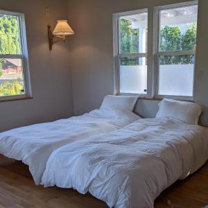 zwei Betten in einem Zimmer mit zwei Fenstern in der Unterkunft Kaeda Terrace - Vacation STAY 69516v in Miyazaki