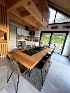 een eetkamer met een grote houten tafel en stoelen bij Les grands Combes in Saint-Léger-les-Mélèzes