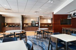 a dining room with tables and chairs and a tv at Fairfield Inn & Suites by Marriott Austin San Marcos in San Marcos