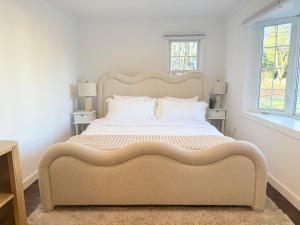 a large bed in a bedroom with two windows at Norwalk Retreat in Norwalk