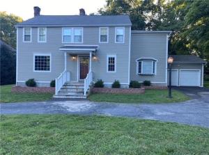 a gray house with a porch and a driveway at Norwalk Retreat in Norwalk