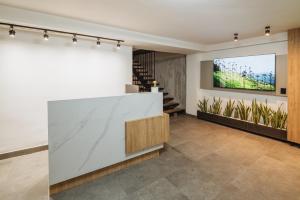 a lobby with a white counter and a wall with plants at Green House Hotel in Salento
