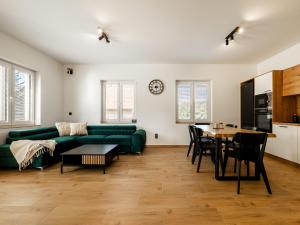 a living room with a green couch and a table at Apartmány Bližší Lhota in Bližší Lhota