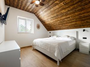 a bedroom with a white bed and a wooden ceiling at Apartmány Bližší Lhota in Bližší Lhota
