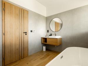 a bathroom with a tub and a sink and a mirror at Apartmány Bližší Lhota in Bližší Lhota