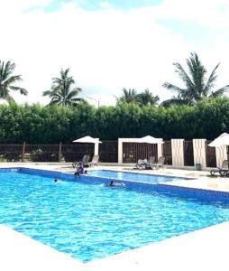 una piscina con acqua blu e ombrelloni di Hawana Salalah Rosely Studio a Salalah Altre 5 foto