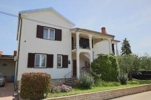 een wit huis met zwarte luiken erop bij Apartment Luciana in Umag