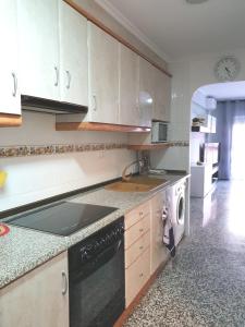 拉波夫拉德法尔纳尔斯Pobla de Farnals BEACH APARTMENT的厨房配有白色橱柜、水槽和洗碗机