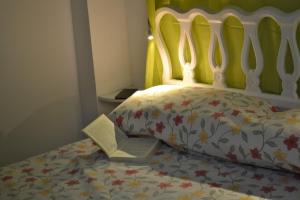 拉波夫拉德法尔纳尔斯Pobla de Farnals BEACH APARTMENT的床上的被子和书上写的