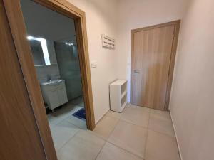 a bathroom with a toilet and a sink and a door at Apartments Kod Cara in Lokva Rogoznica