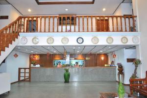 a lobby with clocks on the wall and a counter at Myanmar Life Hotel in Yangon