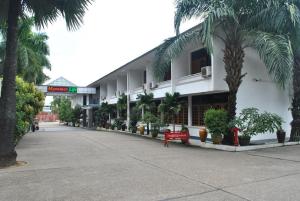 a building with palm trees in front of it at Myanmar Life Hotel in Yangon