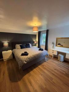 ein Schlafzimmer mit einem großen Bett und einem Spiegel in der Unterkunft Large country house with garden, outdoor spa area & games room with Hot Tub and Fire Pit in Wigtown