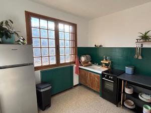 a kitchen with a refrigerator and a sink at Gîte Le Chicateou in Le Dévoluy