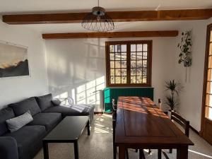 a living room with a couch and a table at Gîte Le Chicateou in Le Dévoluy