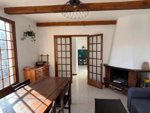 a living room with a table and a fireplace at Gîte Le Chicateou in Le Dévoluy