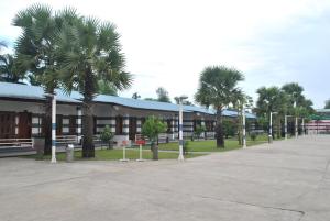 a building with palm trees in a parking lot at Myanmar Life Hotel in Yangon