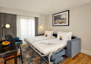 a hotel room with two beds and a table at Citadines Barbican London in London +19 photos