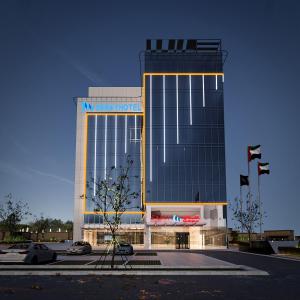 アブダビにあるSaray Deluxe Hotel Apartmentsの正面に看板がある大きな建物