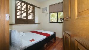 Un pat sau paturi într-o cameră la RedDoorz @ Hilarion's Farm Majayjay, Laguna