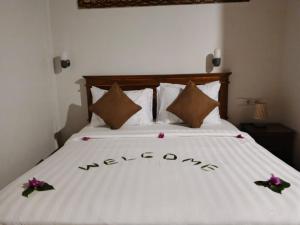 a bedroom with a bed with flowers on it at Jay Guest House Gili Gede in Sekotong