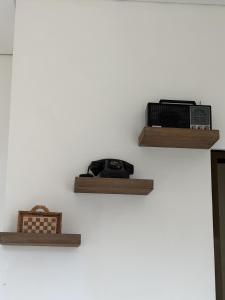 a wall with two wooden shelves on a wall at Pandan de Bali in Ungasan
