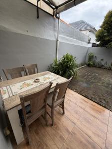 a wooden table and chairs on a patio at Pandan de Bali in Ungasan