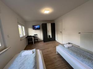 a bedroom with two beds and a tv on the wall at 92 City Rooms in Koblenz