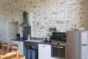 a kitchen with a sink and a microwave at Gîte les charrières in Pouzauges +16 photos