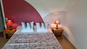 a bedroom with a bed with two lamps on tables at Gîte les charrières in Pouzauges