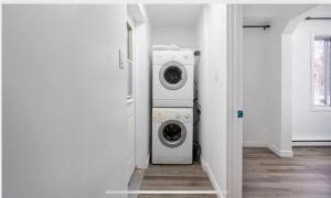 een wasruimte met een wasmachine en droger. bij Comfortable 4B Unit-Close to City Attractions in Montreal