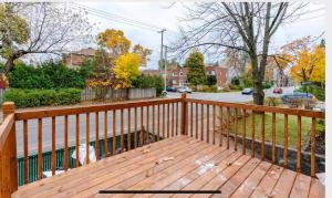 een houten terras met een hek aan een straat bij Comfortable 4B Unit-Close to City Attractions in Montreal