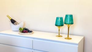 two wine glasses sitting on a white dresser at Bon Bon Suite by Ca-sa Check in Sottomarina