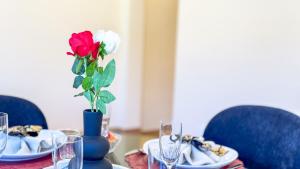 a table with a blue vase with a rose in it at Bon Bon Suite by Ca-sa Check in Sottomarina