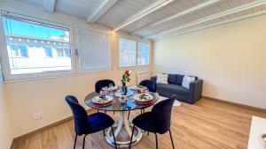 a living room with a table with chairs and a couch at Bon Bon Suite by Ca-sa Check in Sottomarina