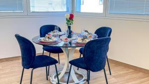 a dining room table with blue chairs and a table with a table at Bon Bon Suite by Ca-sa Check in Sottomarina +21 photos