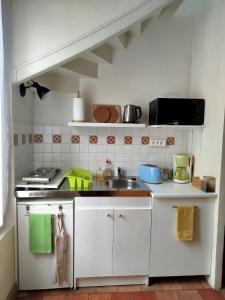 een witte keuken met een spoelbak en een fornuis bij Escale tourangelle in Monts