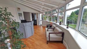a large room with a hallway with a couch and windows at The Glenerne in Eyemouth