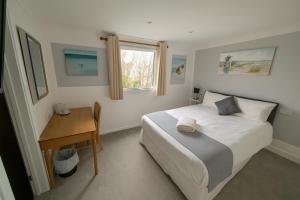 a bedroom with a bed and a desk and a window at Cecil Court Hotel in Bournemouth +20 photos