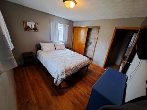 a small bedroom with a bed and a wooden floor at Location! Large Home, Country Views, Entertainment in Dubuque