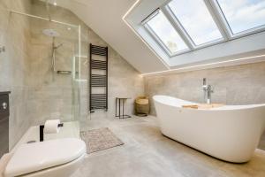 een badkamer met een wit bad en een dakraam bij 5 Bed in Pancrasweek oc-l30443 in Pancrasweek +35 foto's