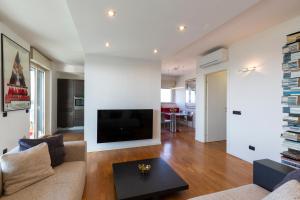 a living room with a couch and a tv at Settimo Cielo - San Cristoforo in Milan +43 photos