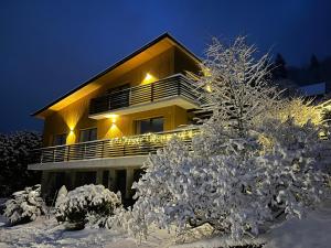 a building with snow covered trees in front of it at Dom i Las in Brenna +72 photos